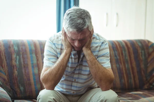 Upprörd äldre man sitter i vardagsrummet — Stockfoto