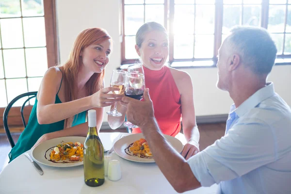 Freunde stoßen auf Wein an — Stockfoto