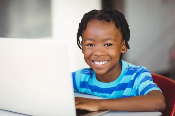 Skolpojke med laptop på skolan — Stockfoto