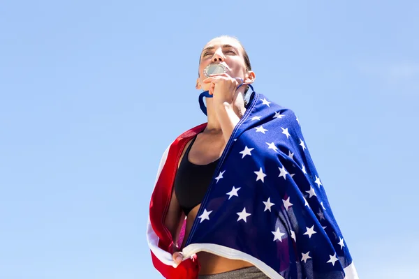 Female athlete kissing her gold medal — Stock Photo, Image