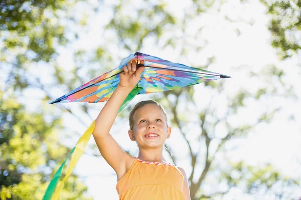 Smiling girl holding kite in park — Stock Photo, Image