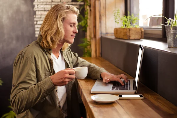 Człowiek za pomocą laptopa w kafeterii — Zdjęcie stockowe