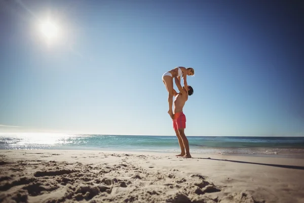 Homem levantando mulher na praia — Fotografia de Stock