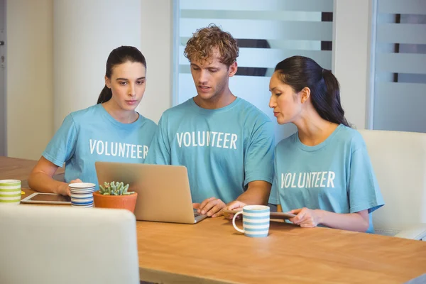 Voluntários usando um laptop — Fotografia de Stock