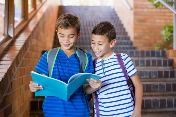 Crianças da escola lendo um livro — Fotografia de Stock