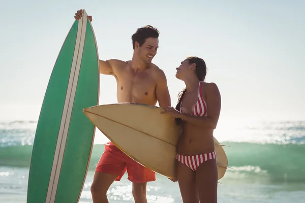 Пара, що стоїть з дошкою для серфінгу на пляжі — стокове фото