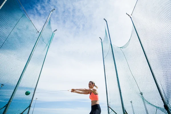Kadın atlet bir çekiç gerçekleştirme atmak — Stok fotoğraf