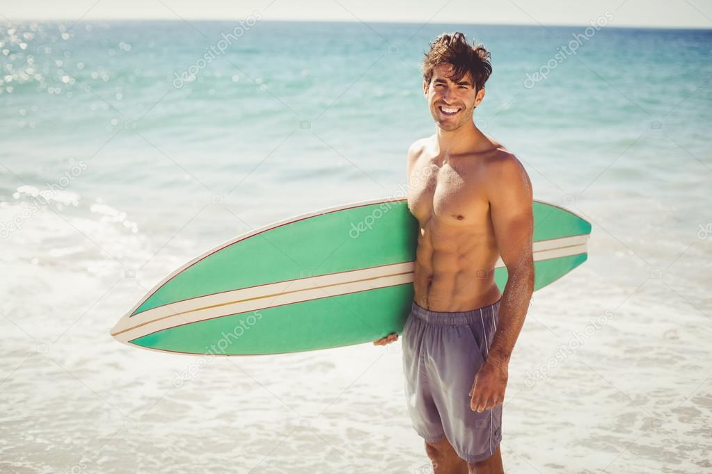 Man holding surfboard on beach Stock Photo by ©Wavebreakmedia 112876924