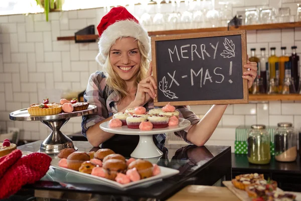 Mujer sosteniendo pizarra con feliz navidad —  Fotos de Stock