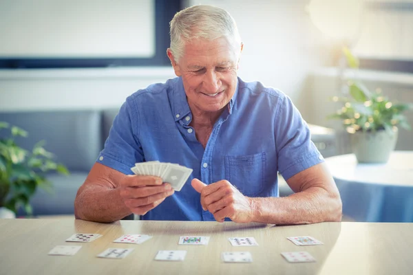 Ανώτερος άνθρωπος παίζουν χαρτιά στο σαλόνι — Φωτογραφία Αρχείου