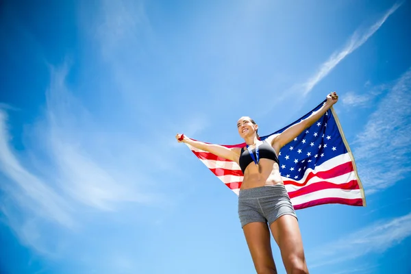 Šťastné ženy sportovec drží americká vlajka — Stock fotografie