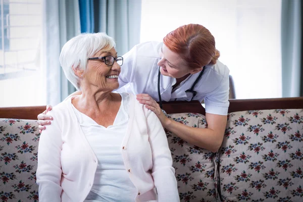 Lachende arts praten met een gelukkig senior vrouw — Stockfoto