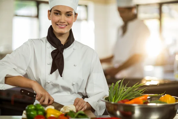 Vrouwelijke chef-kok snijden groenten — Stockfoto