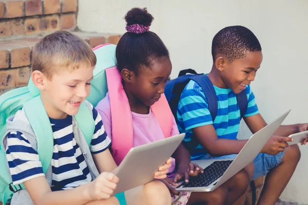 Lachende kinderen met laptop en tablet — Stockfoto