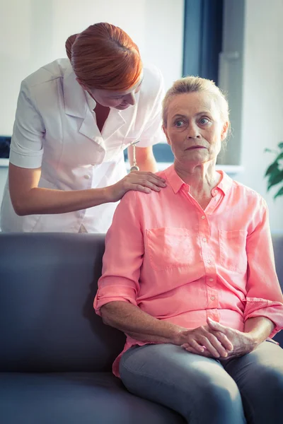 Enfermeira do sexo feminino consoladora mulher idosa — Fotografia de Stock