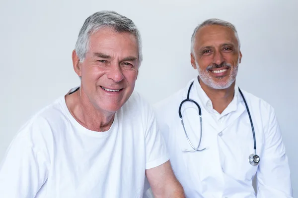 Portrait of happy male doctor and senior man — Stock Photo, Image