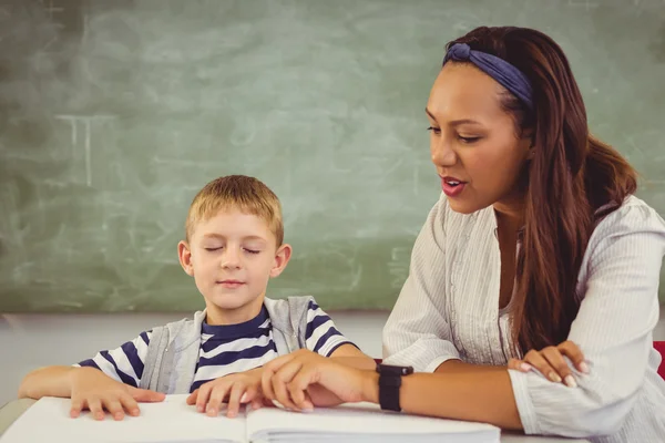 Enseignant aider un garçon avec ses devoirs — Photo