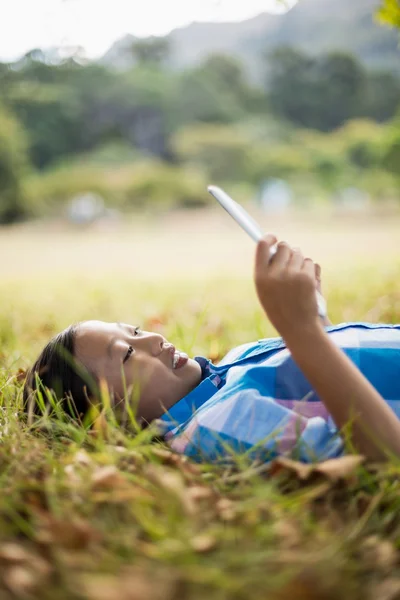 Dívka na trávě pomocí tabletu — Stock fotografie