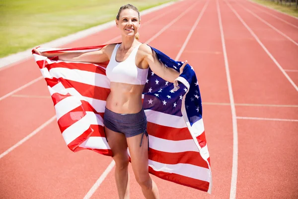 Glückliche Athletin hält amerikanische Flagge hoch — Stockfoto