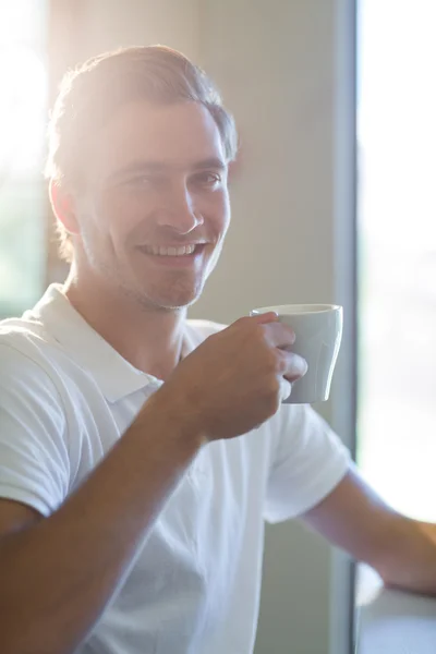 Homme souriant ayant une tasse de café — Photo