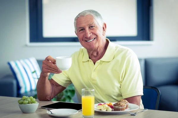 Senior man having tea with breakfast — Stock Photo, Image