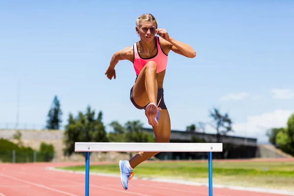 Sportiv feminin sărind deasupra obstacolului — Fotografie, imagine de stoc