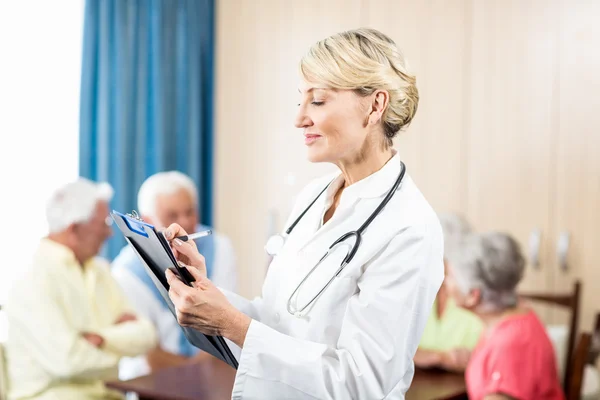 Nurse writing on clipboard — Stock Photo, Image