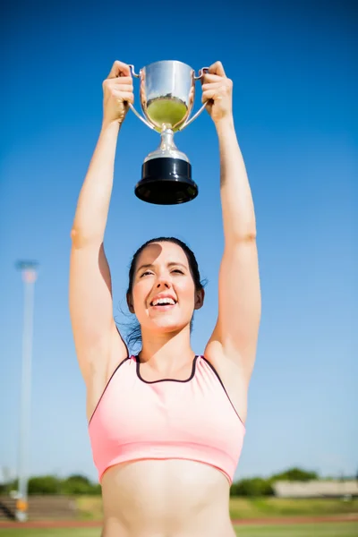 Feliz atleta feminina mostrando seu troféu — Fotografia de Stock