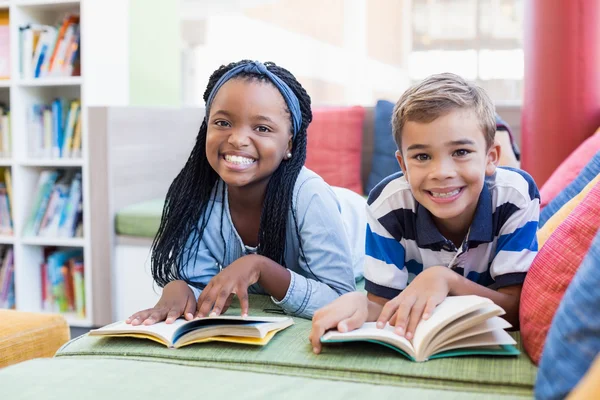 Escuela niños en sofá libro de lectura — Foto de Stock