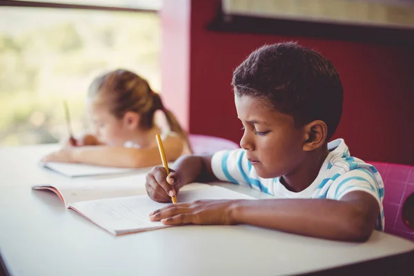 Niños de la escuela haciendo deberes en el aula —  Fotos de Stock