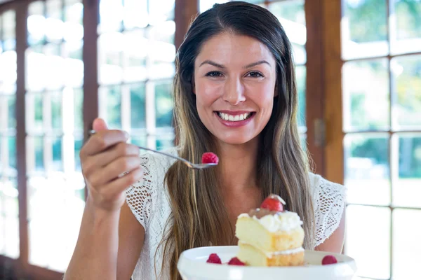 Kvinna med en bakelse i restaurang — Stockfoto