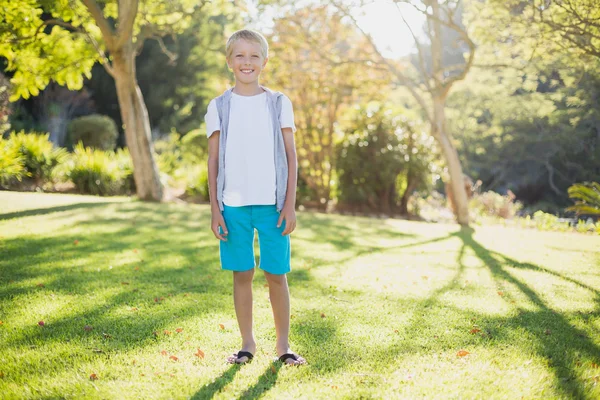 Smiling boy standing in park — Stock Photo, Image