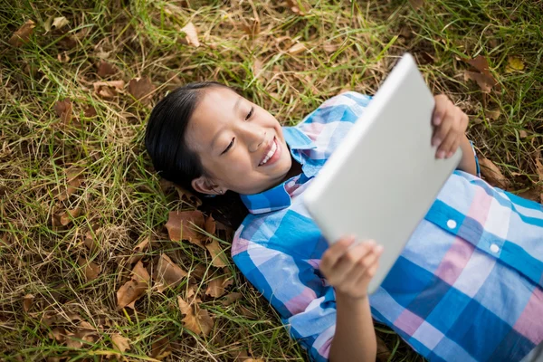 Девушка на траве с помощью планшета — стоковое фото