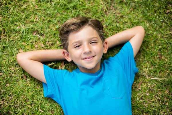 Young boy lying on grass — Stok fotoğraf