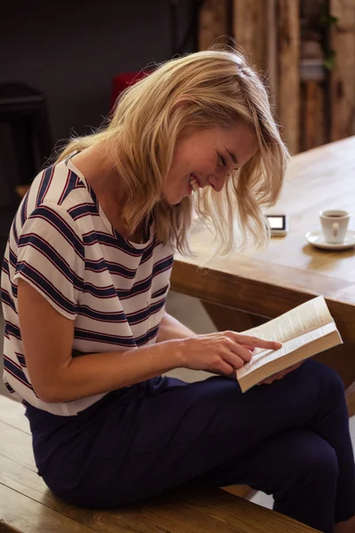 Kadın bir kitap oturma okuma — Stok fotoğraf