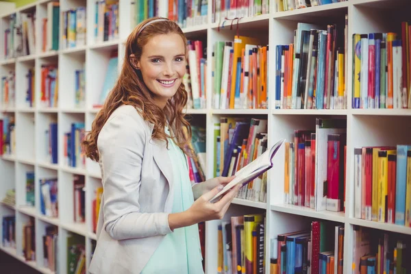 School teacher holding book in library — Stock Photo, Image