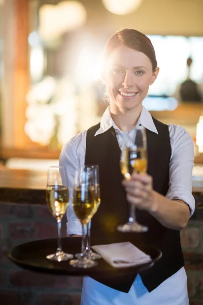 Cameriera che offre un bicchiere di champagne — Foto Stock