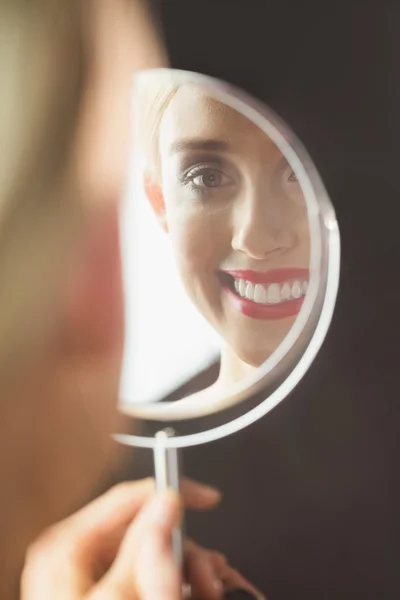 Frau schaut ihr in den Spiegel — Stockfoto