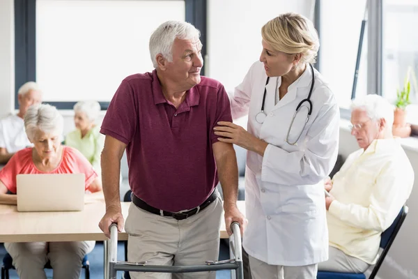 Verpleegkundige helpen senior met het lopen van de steun — Stockfoto