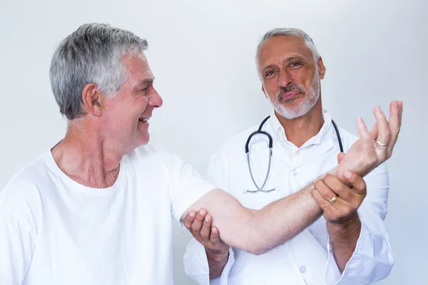 Doctor giving palm acupressure treatment to senior man — Stock Photo, Image