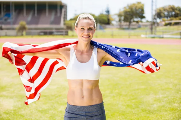 Portrait of female athlete wrapped in american flag — Stock Photo, Image