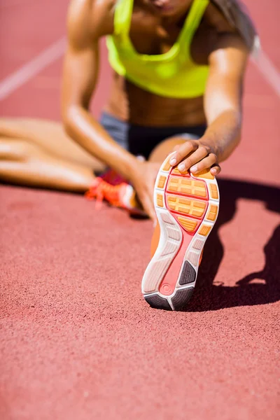 Жінка-спортсменка зігрівається на біговій доріжці — стокове фото