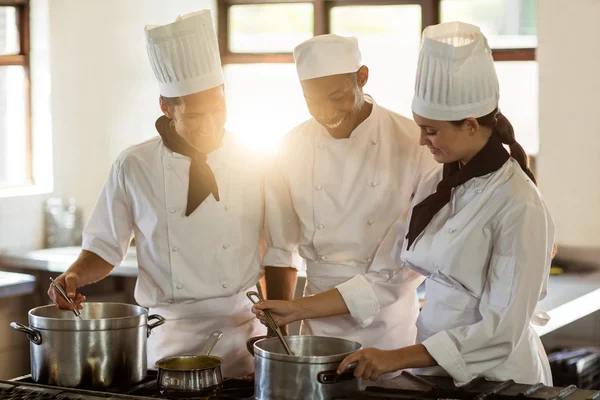 Chefe de cozinha trabalhando com colegas — Fotografia de Stock