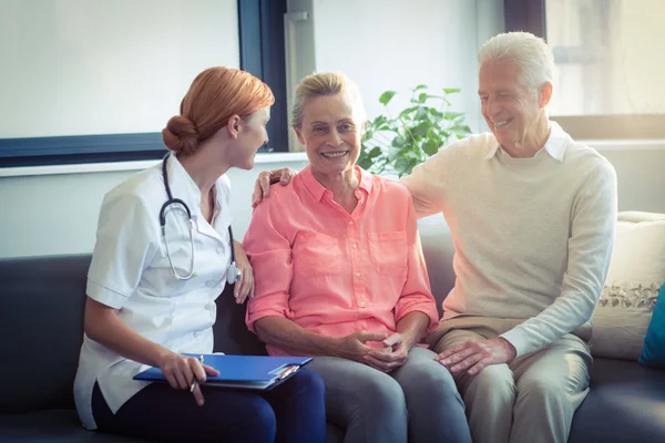 Doctor and senior couple interacting with each other — Stock Photo, Image