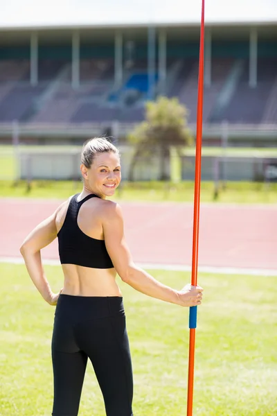 Retrato de una atleta feliz sosteniendo una jabalina — Foto de Stock