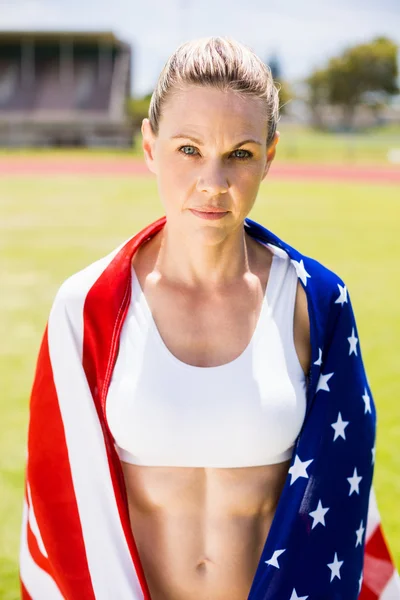 Portrait of female athlete wrapped in american flag — Stock Photo, Image