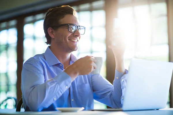 Uomo che utilizza il telefono con caffè — Foto Stock