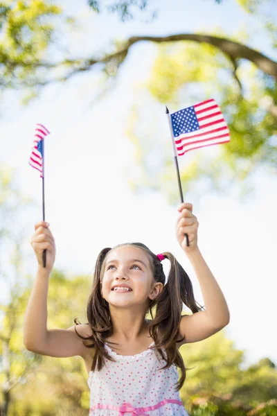 Söt flicka anläggning amerikanska flaggor — Stockfoto