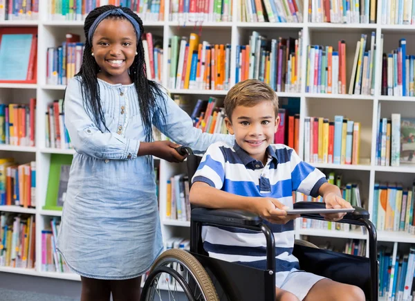 Écolière avec écolier en fauteuil roulant — Photo