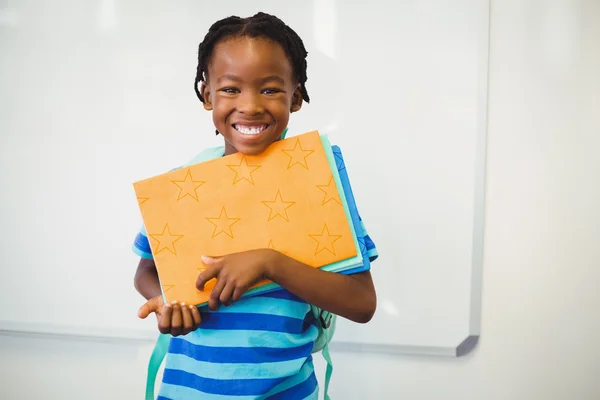 Skolpojke anläggning bok i klassrummet — Stockfoto